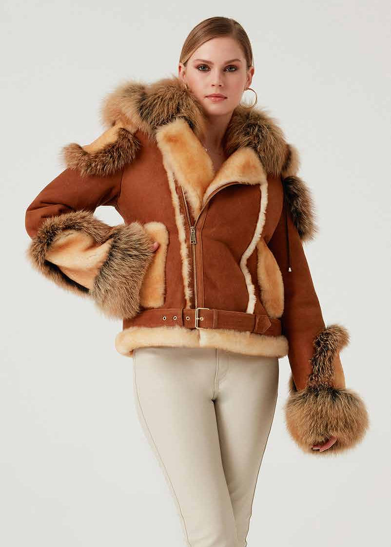Woman wearing a brown shearling jacket with fur trim on a white background