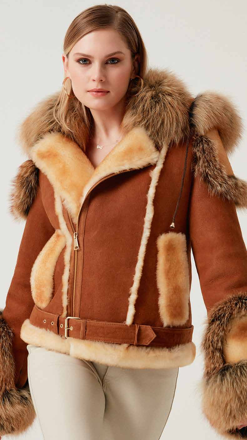 Woman wearing a brown shearling jacket with fur trim on a white background