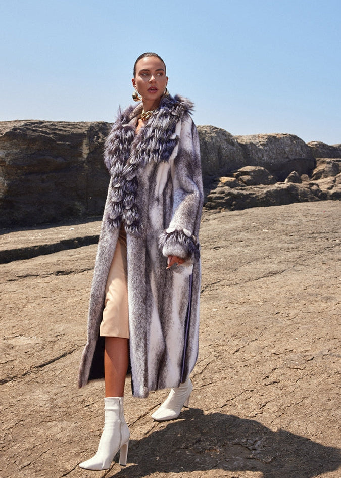 Woman wearing a long fur coat in a desert landscape