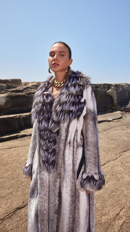 Woman wearing a long fur coat with a rocky landscape background