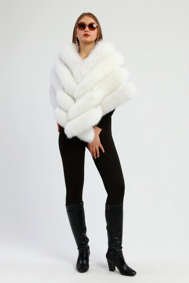 Woman wearing a white fur shawl, black leggings, and black knee-high boots on a white background