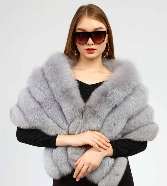 Woman wearing a gray fox fur shawl over a black outfit on a white background