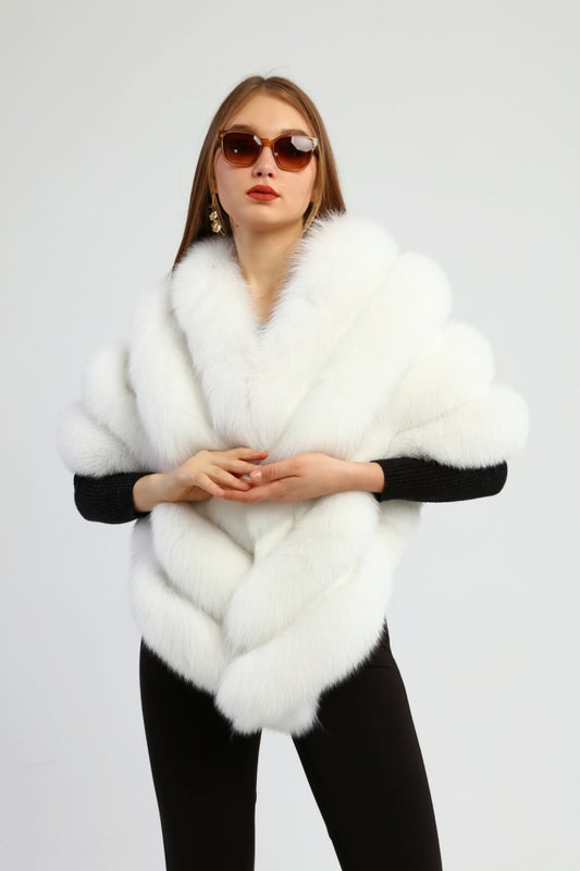 Woman wearing a white fox fur shawl and sunglasses on a light gray background
