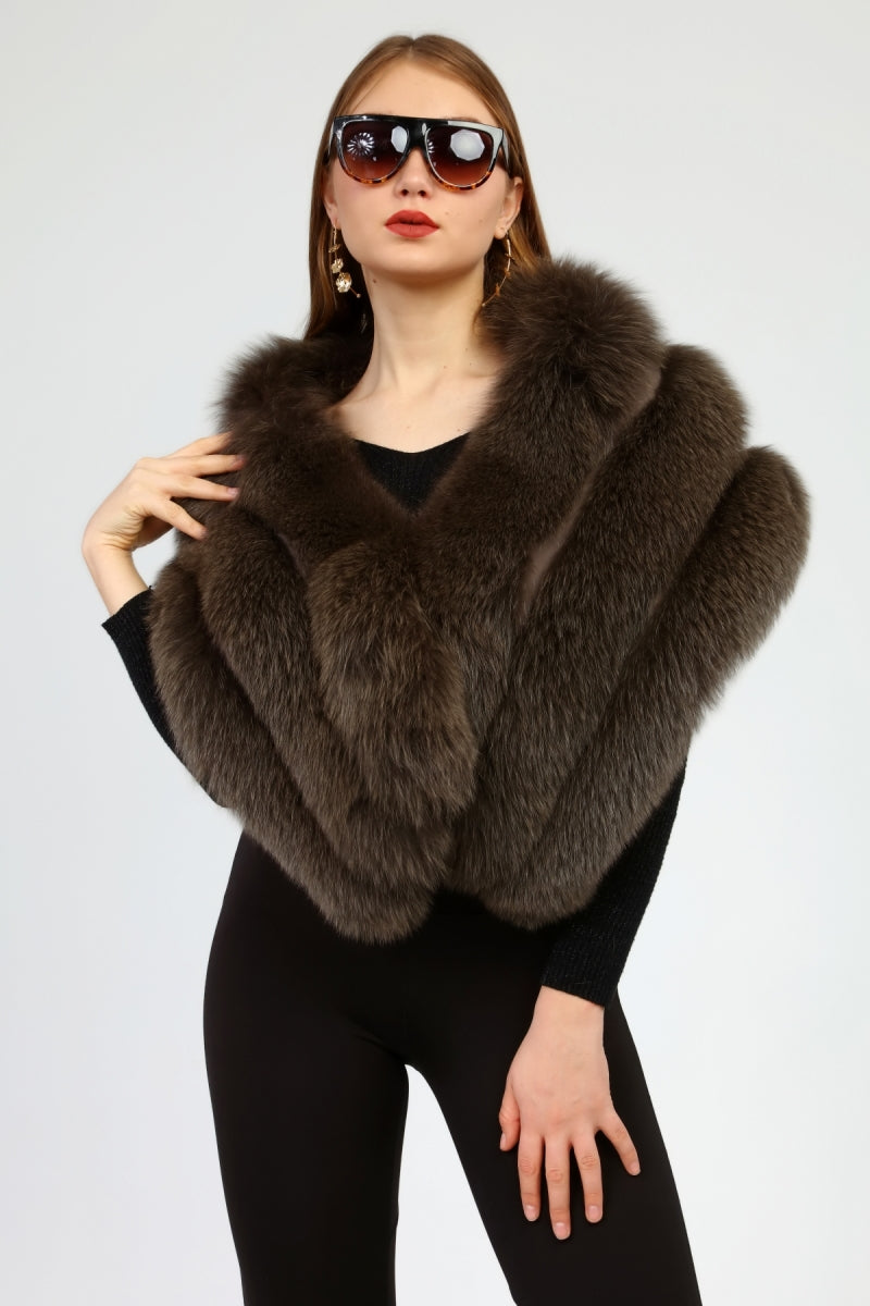 Woman wearing a brown fox fur shawl and sunglasses on a light gray background