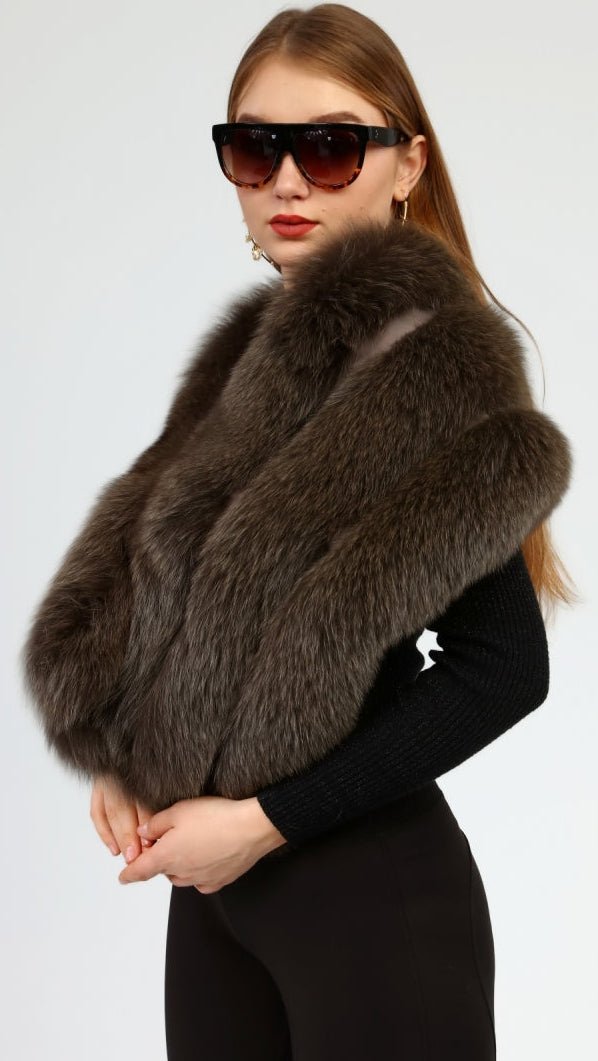 Woman wearing a brown fox fur shawl over a black outfit on a white background