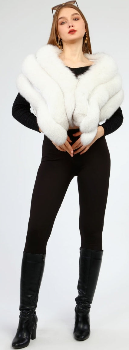 Woman wearing a white fox fur shawl, black outfit, and black boots on a white background