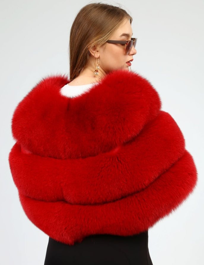 Woman wearing a red fox fur shawl against a white background