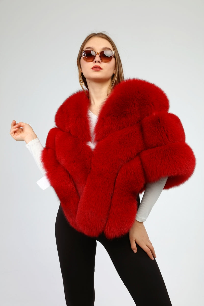Woman wearing a red fox fur shawl on a plain background