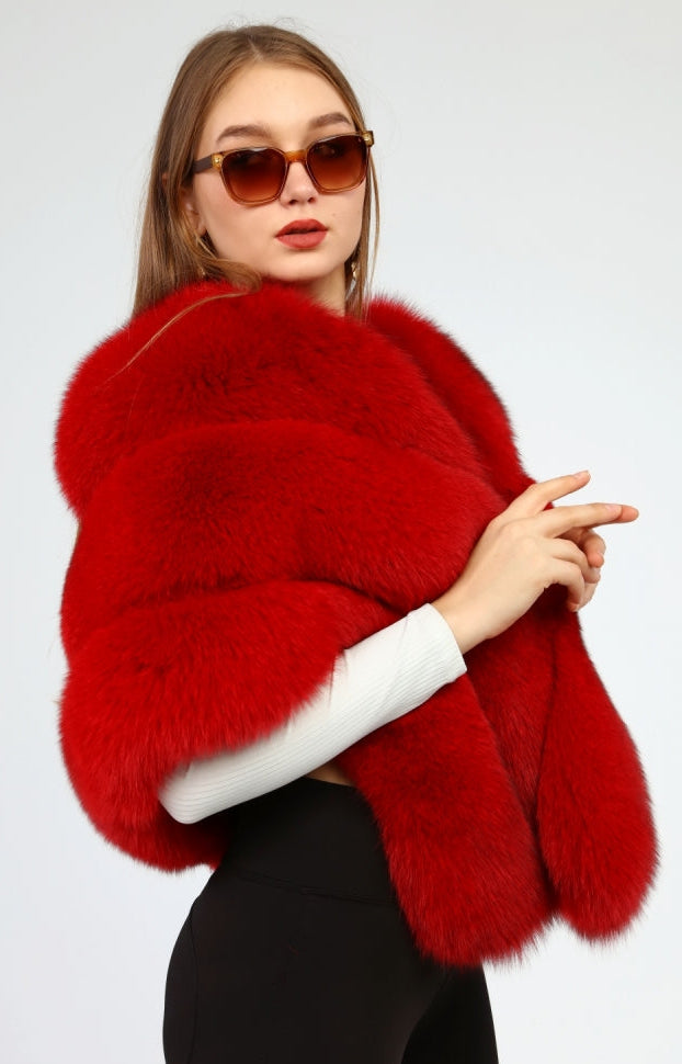 Woman wearing a red fox fur shawl and sunglasses on a white background