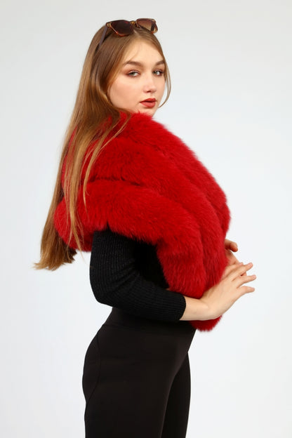 Woman wearing a red fox fur shawl over a black outfit on a white background