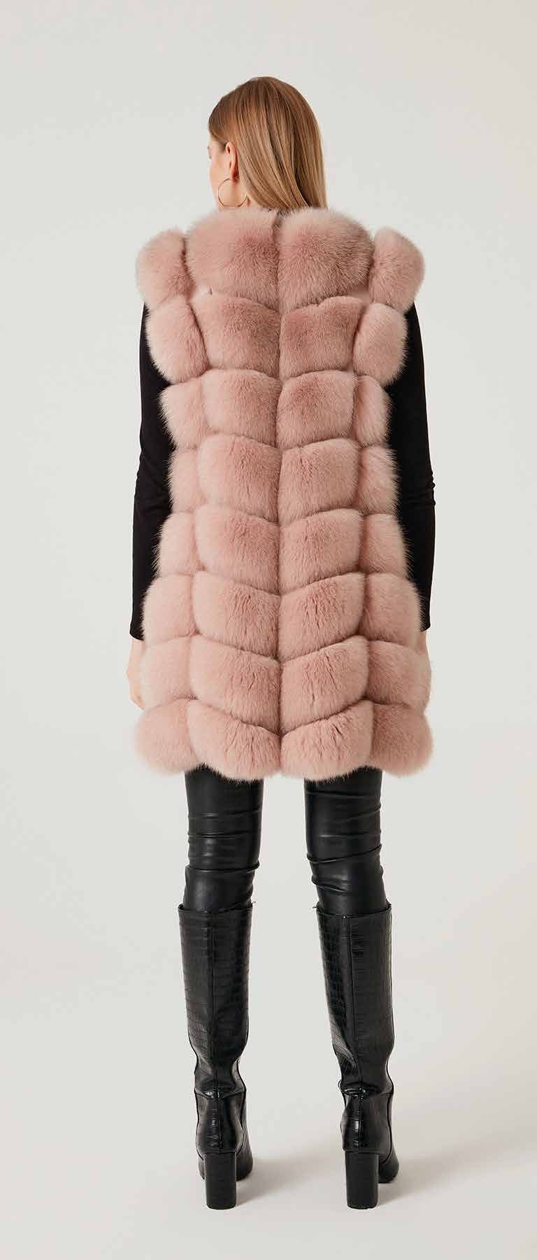 Woman wearing a pink fox fur vest and black boots on a white background
