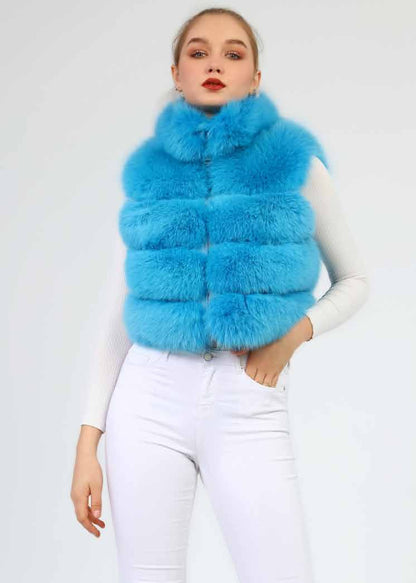 Woman wearing a bright blue fur vest against a white background