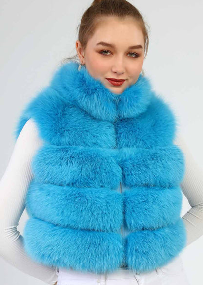 Woman wearing a bright blue fur vest against a white background