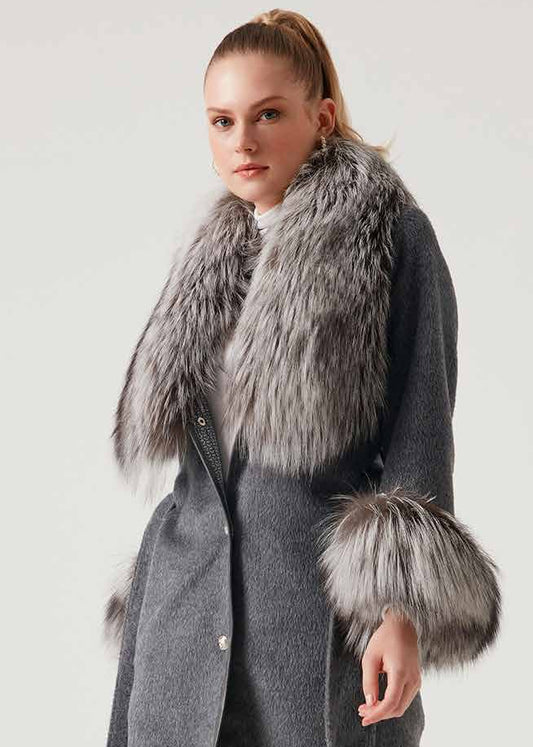 Woman wearing a gray coat with fur trim on a white background