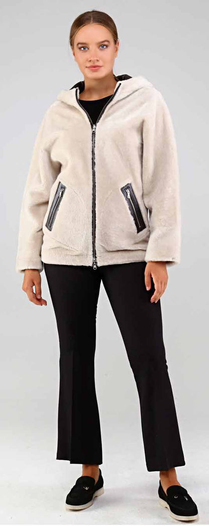 Woman wearing a beige fleece jacket with black pants on a white background
