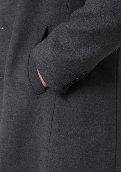 Close-up of a dark gray coat with a buttoned pocket.