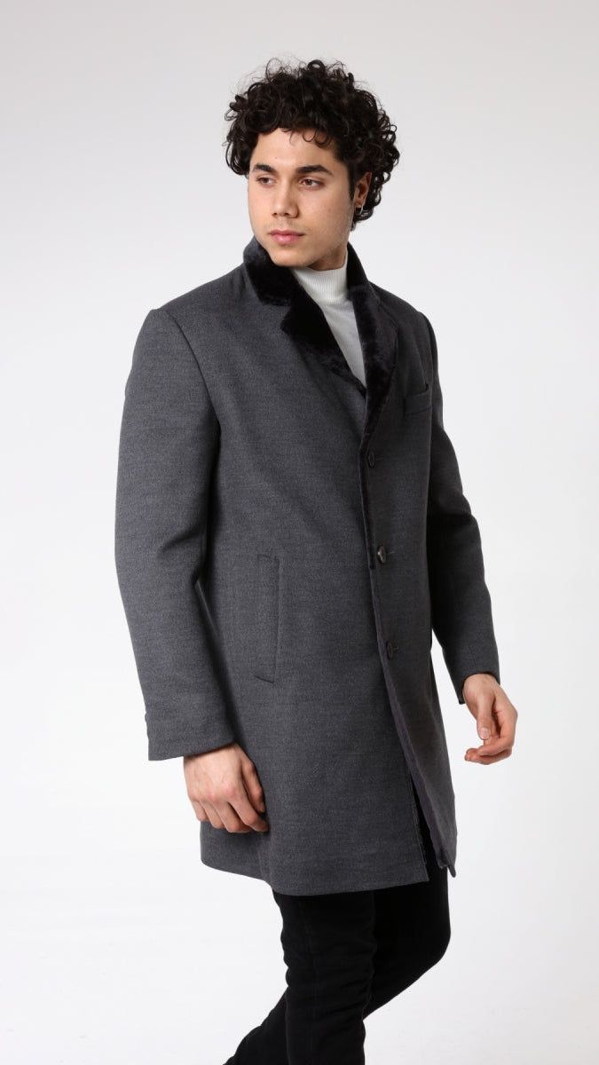 Man wearing a gray coat with a fur collar on a white background