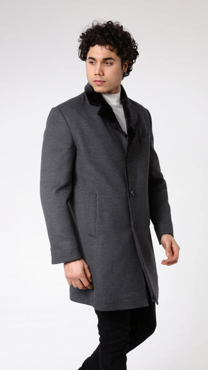 Man wearing a gray coat with a fur collar on a white background