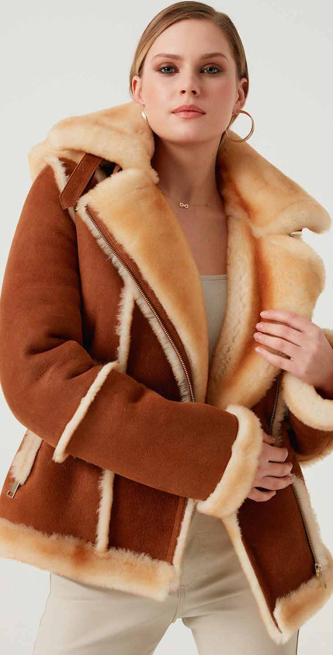 Woman wearing a brown shearling coat with a white background