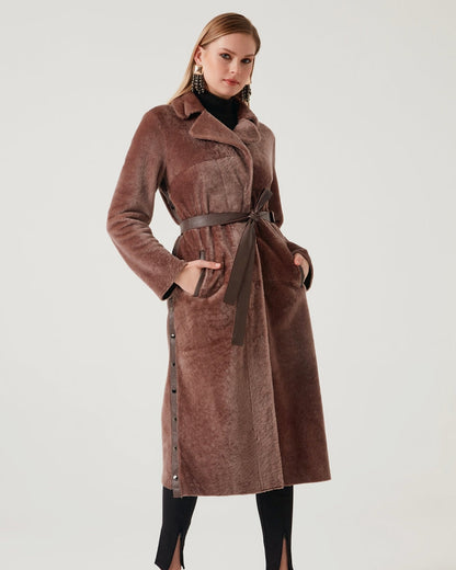 Woman wearing a brown coat with a belt on a white background
