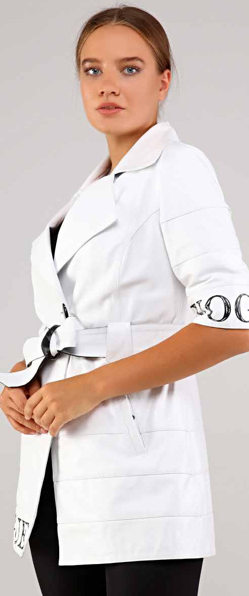 Woman wearing a white coat with a belt on a plain background