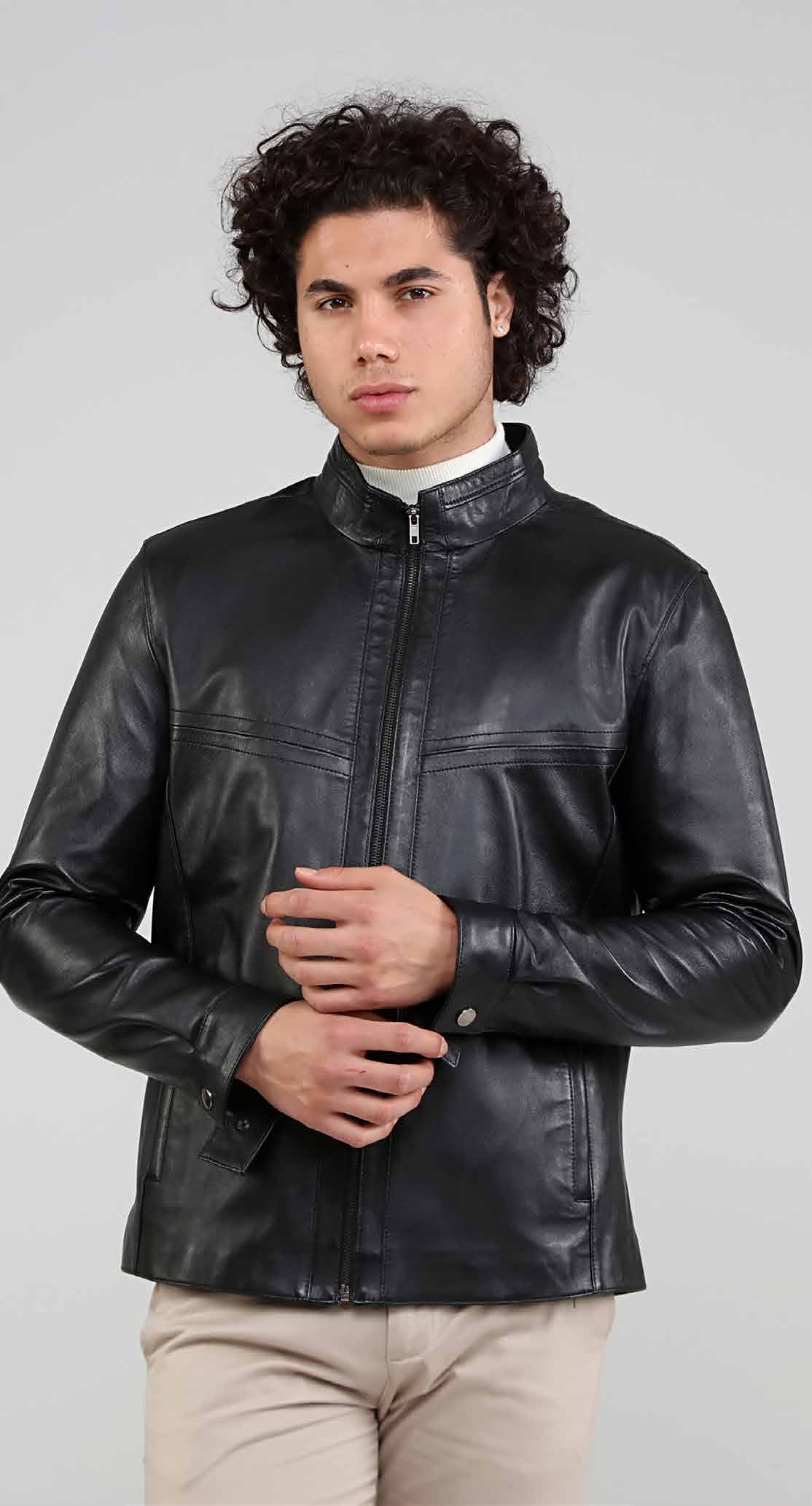 Man wearing a black leather jacket on a gray background