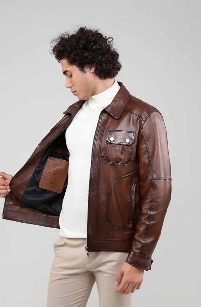 Woman wearing a brown leather jacket over a white shirt on a plain background