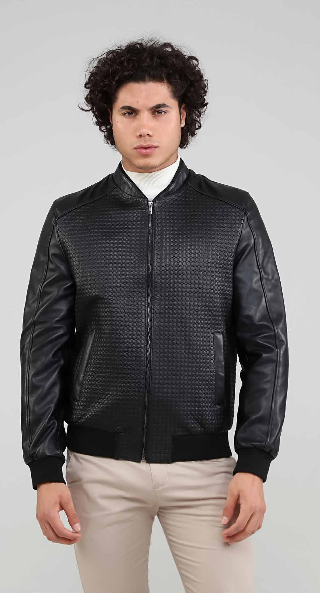 Man wearing a black leather jacket with a textured pattern on a gray background