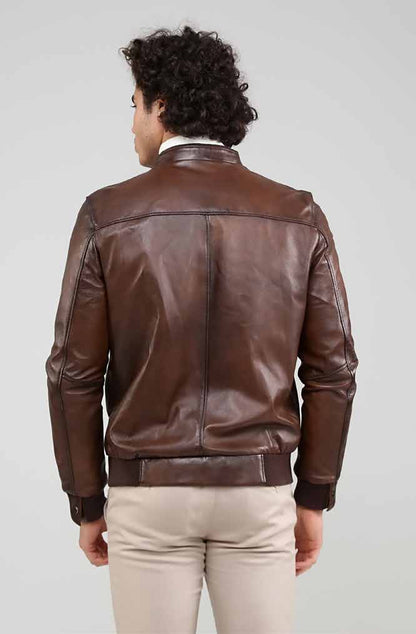 Man wearing a brown leather jacket on a plain background