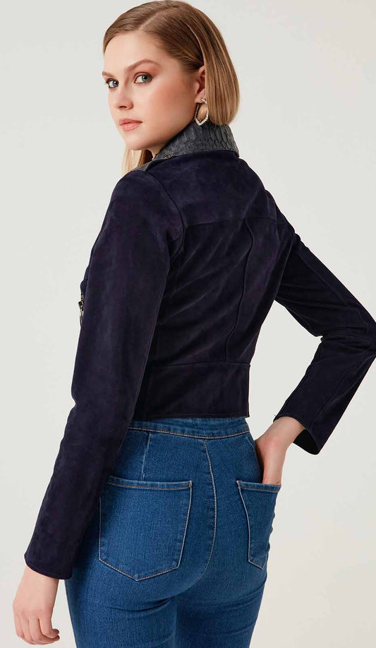 Person wearing a lamb jacket and blue jeans against a white background