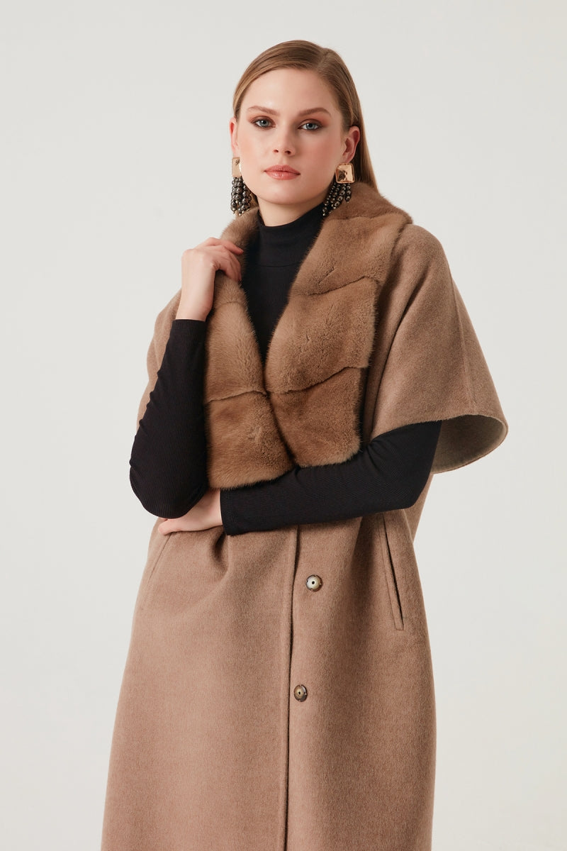 Woman wearing a brown coat with a black top on a white background