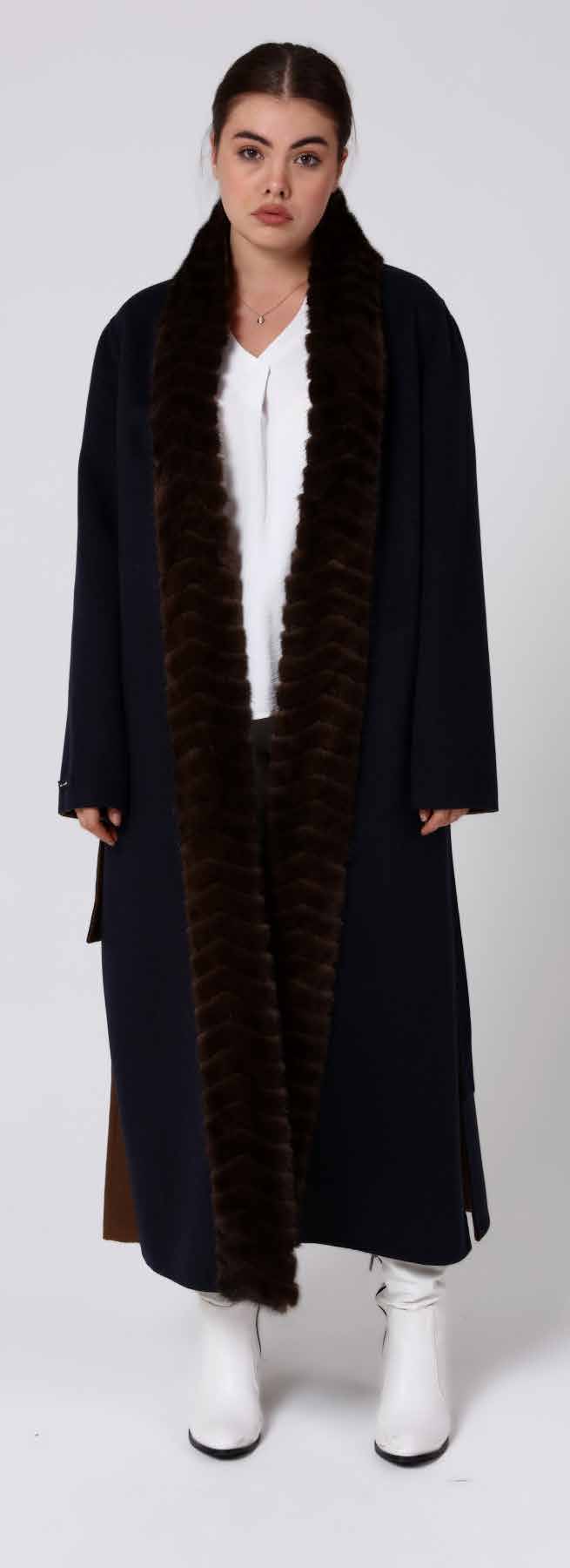 Woman wearing a long dark alpaca coat with a mink fur-lined hood on a white background
