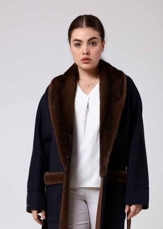 Woman wearing a alpaca overcoat with a mink fur, white pants, and white boots on a white background