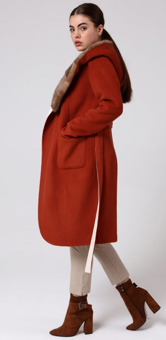 Woman wearing a red coat with fur collar on a white background