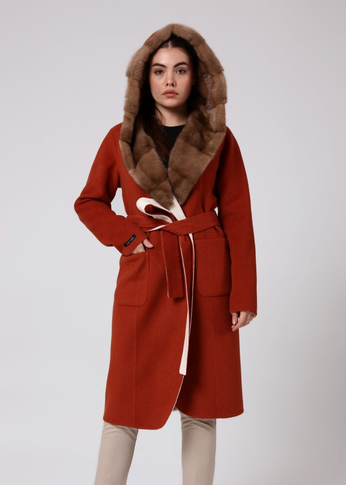 Woman wearing a red coat with fur hood on a white background