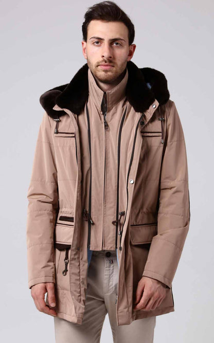 Man wearing a beige coat with fur collar on a white background