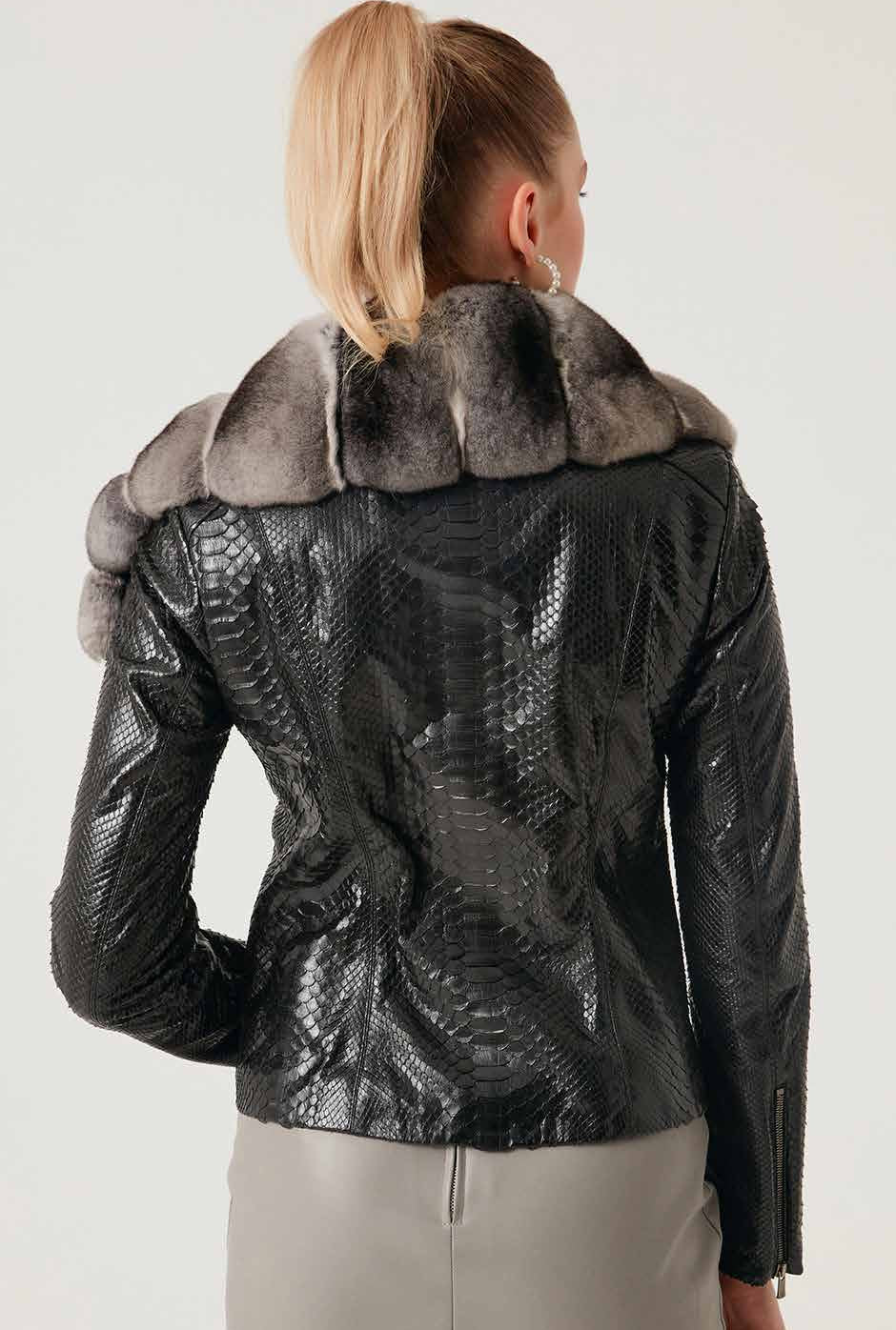 Person wearing a black phyton leather jacket with chinchilla fur collar on a plain background