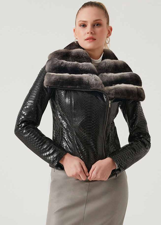 Woman wearing a black phyton leather jacket with chinchilla fur collar and a gray skirt on a white background