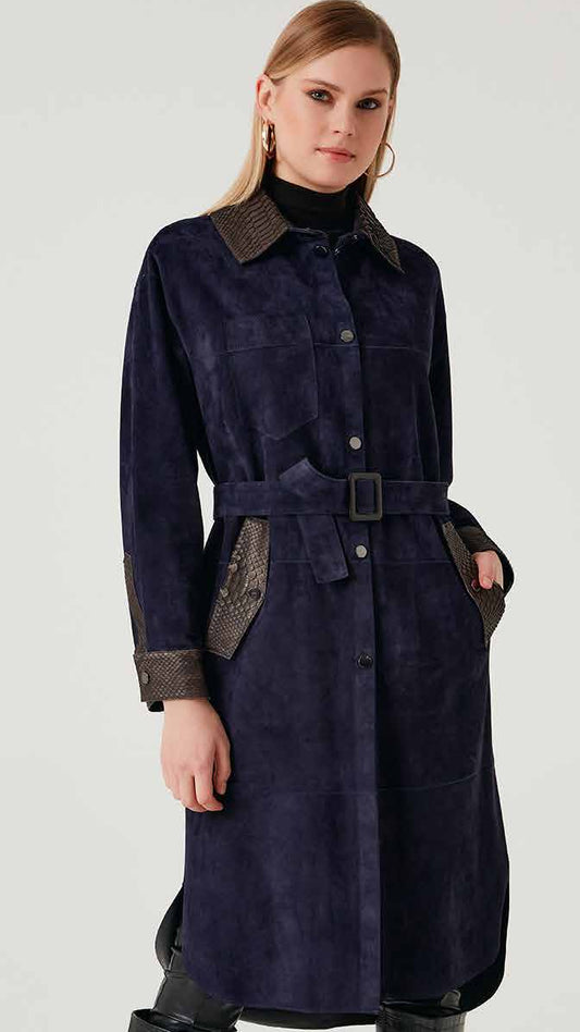 Woman wearing a long navy coat with leather accents on a white background