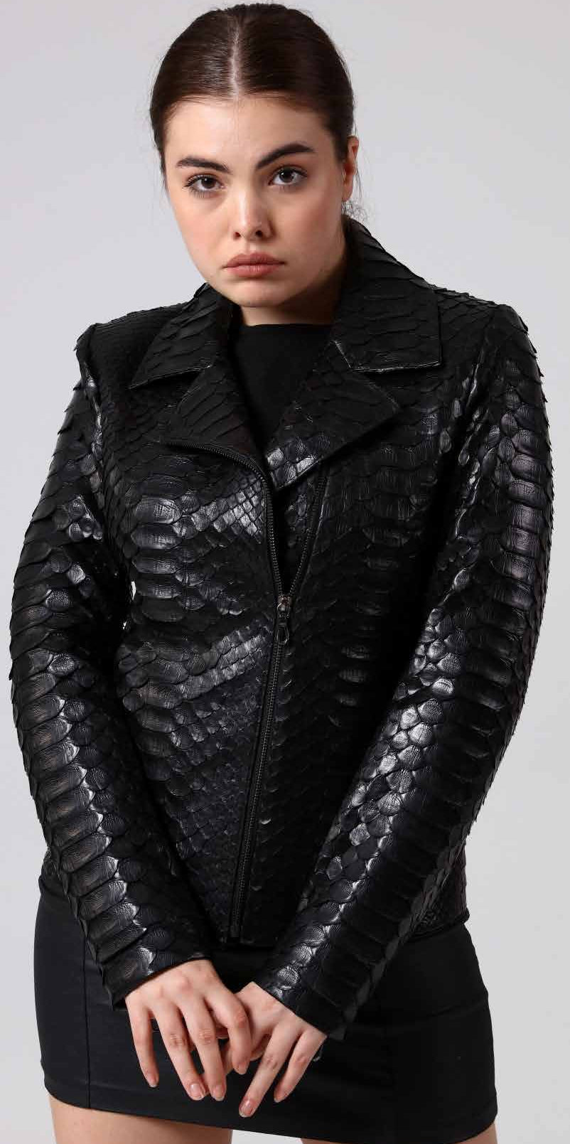 Woman wearing a black phyton leather jacket on a plain background