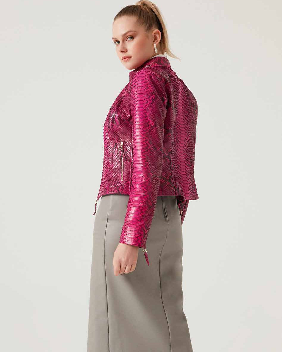 Woman wearing a pink phyton leather jacket and gray skirt on a white background