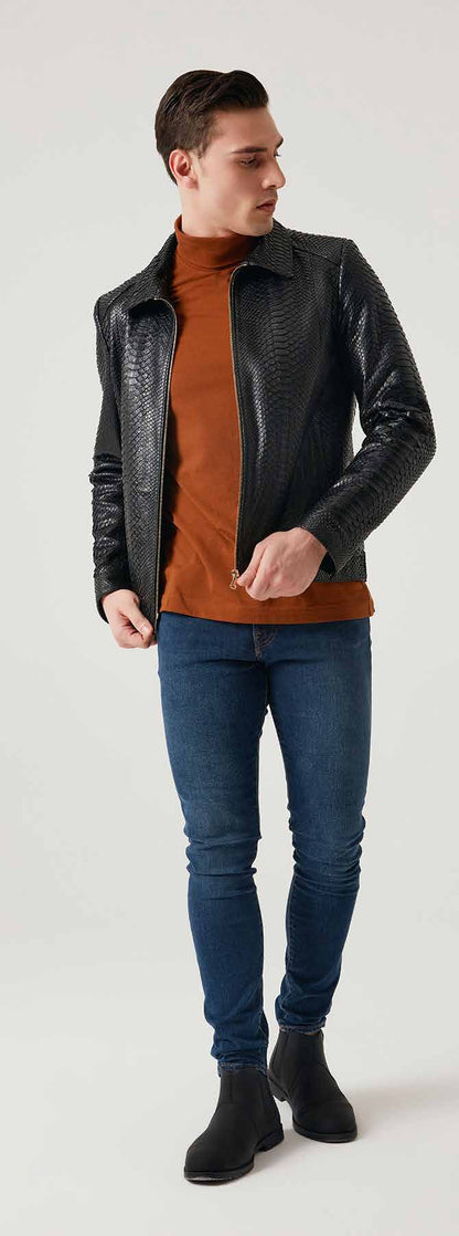 Man wearing a black leather jacket, brown turtleneck, blue jeans, and black shoes on a white background