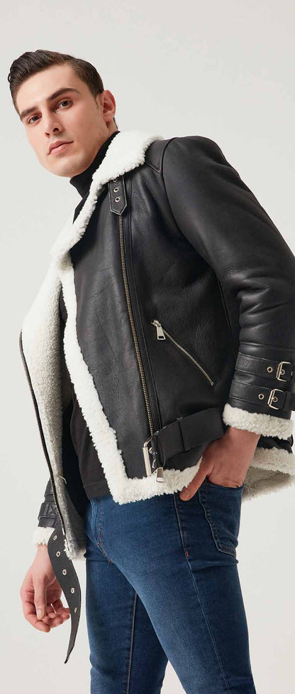 Man wearing a black leather jacket with white fur lining on a plain background