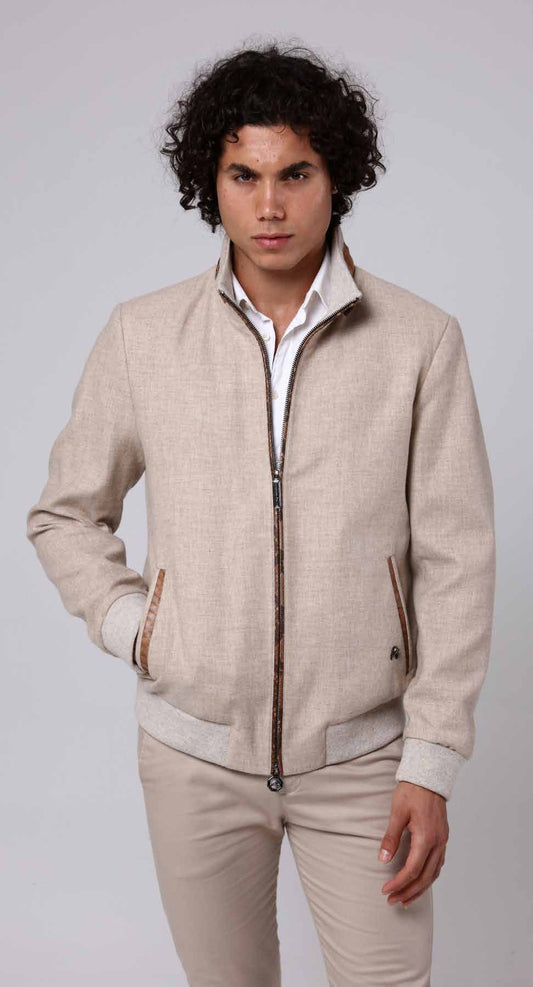 Man wearing a beige jacket and pants on a plain background