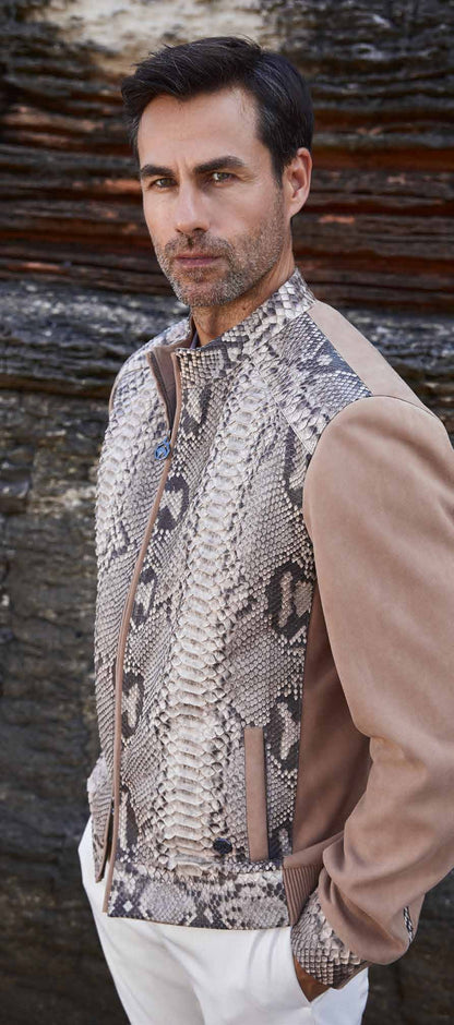 Man wearing a patterned vest over a beige shirt with a wooden background