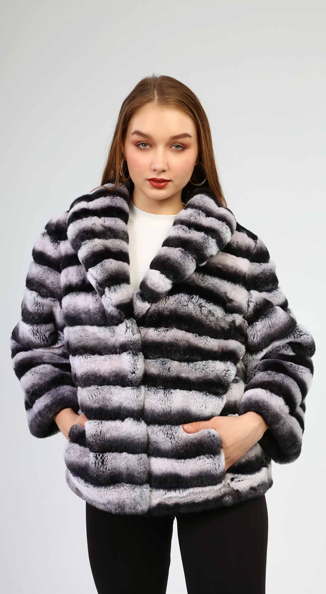 Woman wearing a gray fur coat against a white background