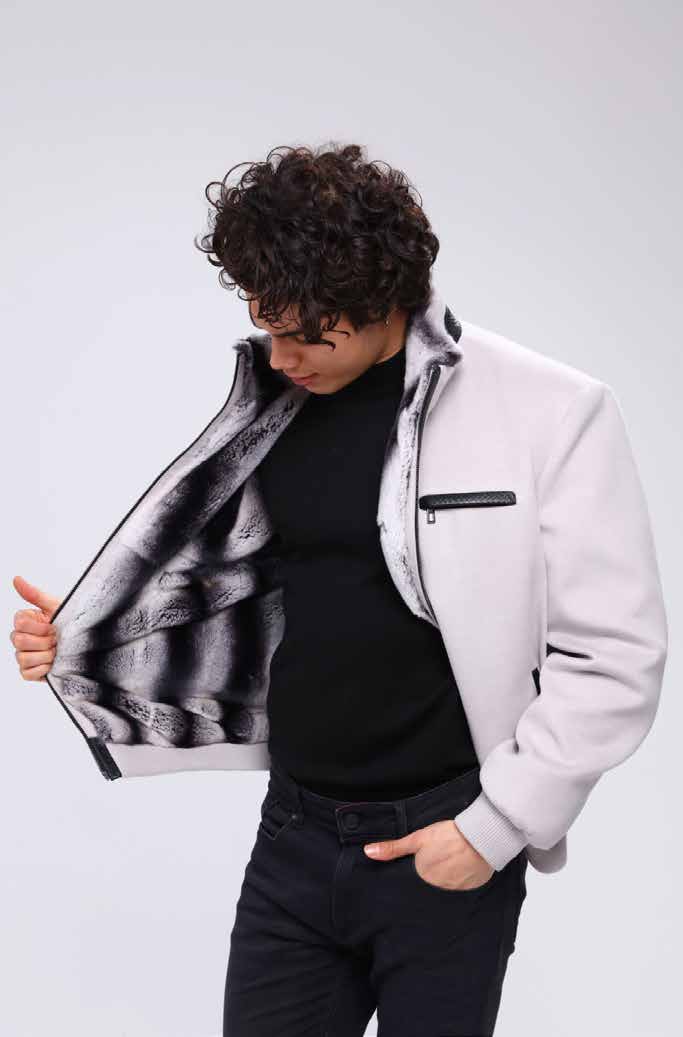 Man wearing a white jacket with a black and white patterned lining, standing against a plain background.