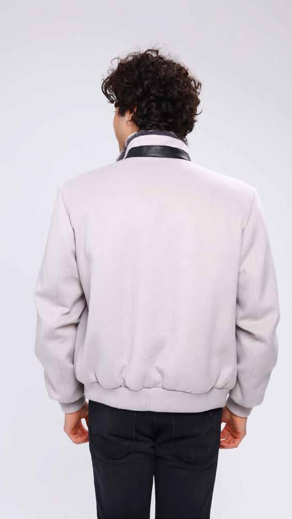 Man wearing a light gray bomber jacket on a white background