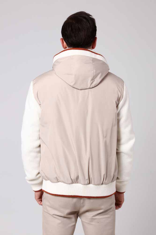 Man wearing a beige bomber jacket and pants on a plain background