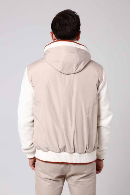 Man wearing a beige bomber jacket and pants on a plain background